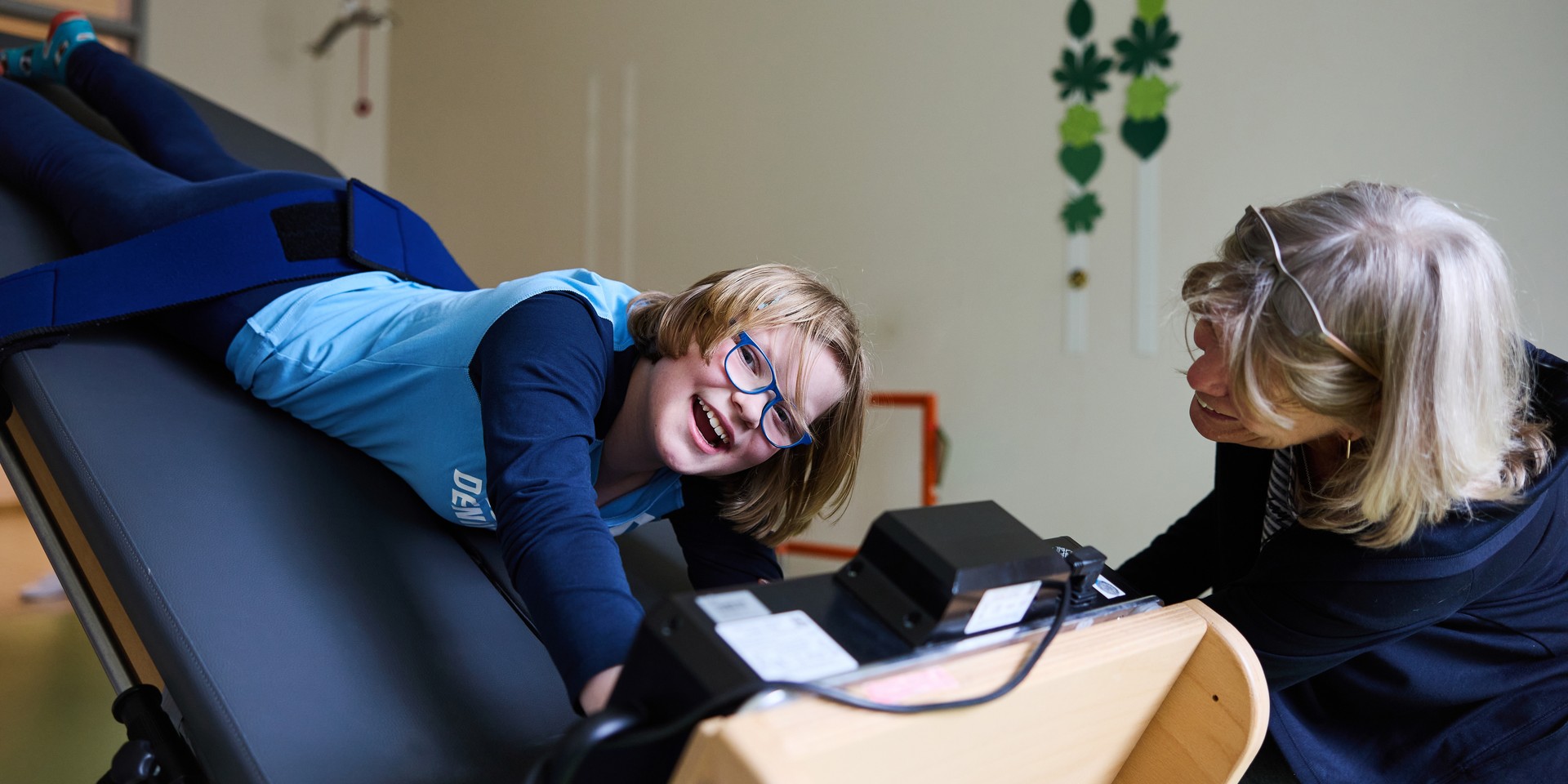 Therapeutin arbeitet mit Schüler, der auf ihrem Schoß sitzt.
