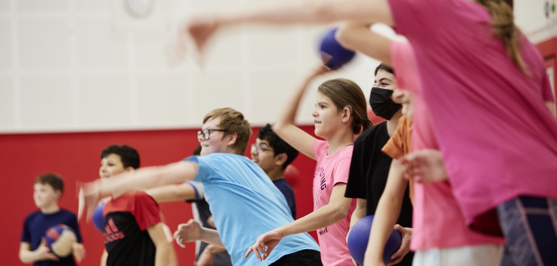 Bild zeigt Kinder in der Turnhalle, die Bälle werfen.