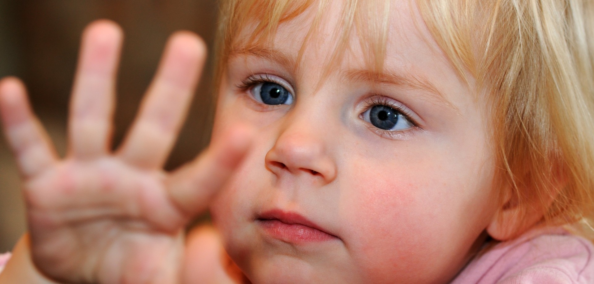 Bild zeigt ein Mädchen, das ihre Finger bestaunt.